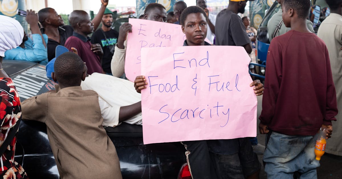 A group of people protest with signs demanding an end to food and fuel scarcity in Nigeria.